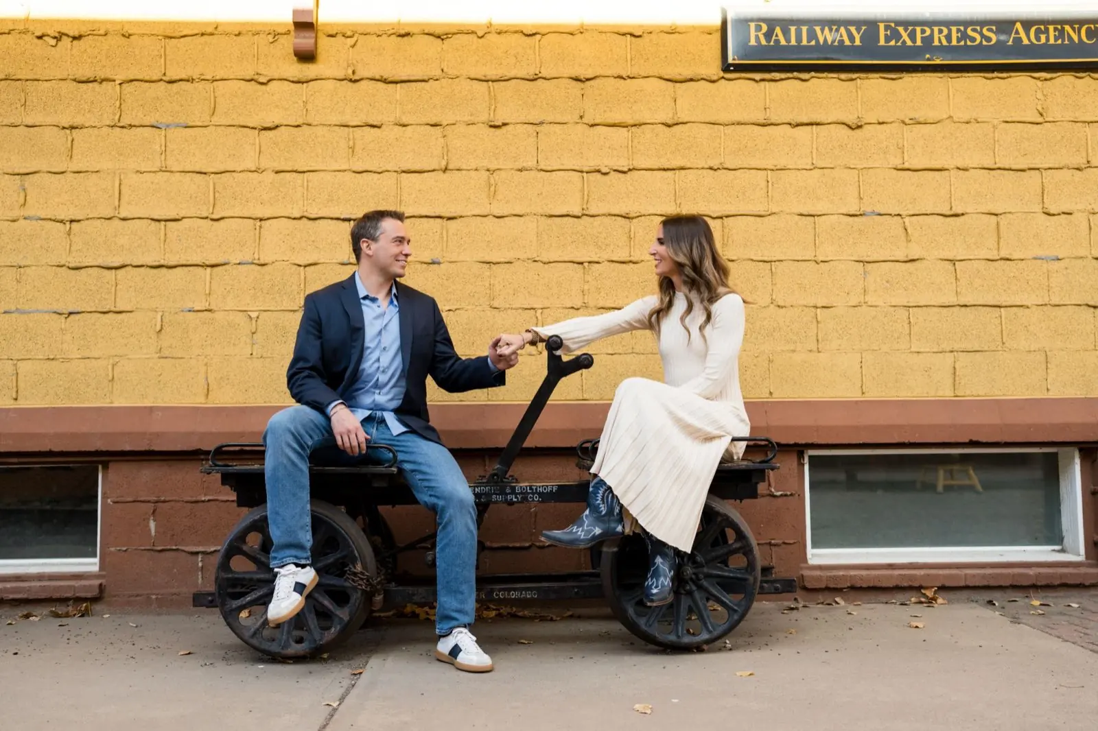 Joey Klein and his wife sitting together, holding hands and laughing