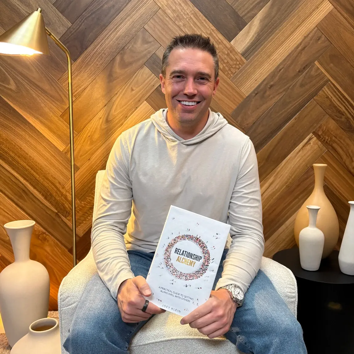 Joey Klein holding a copy of Relationship Alchemy